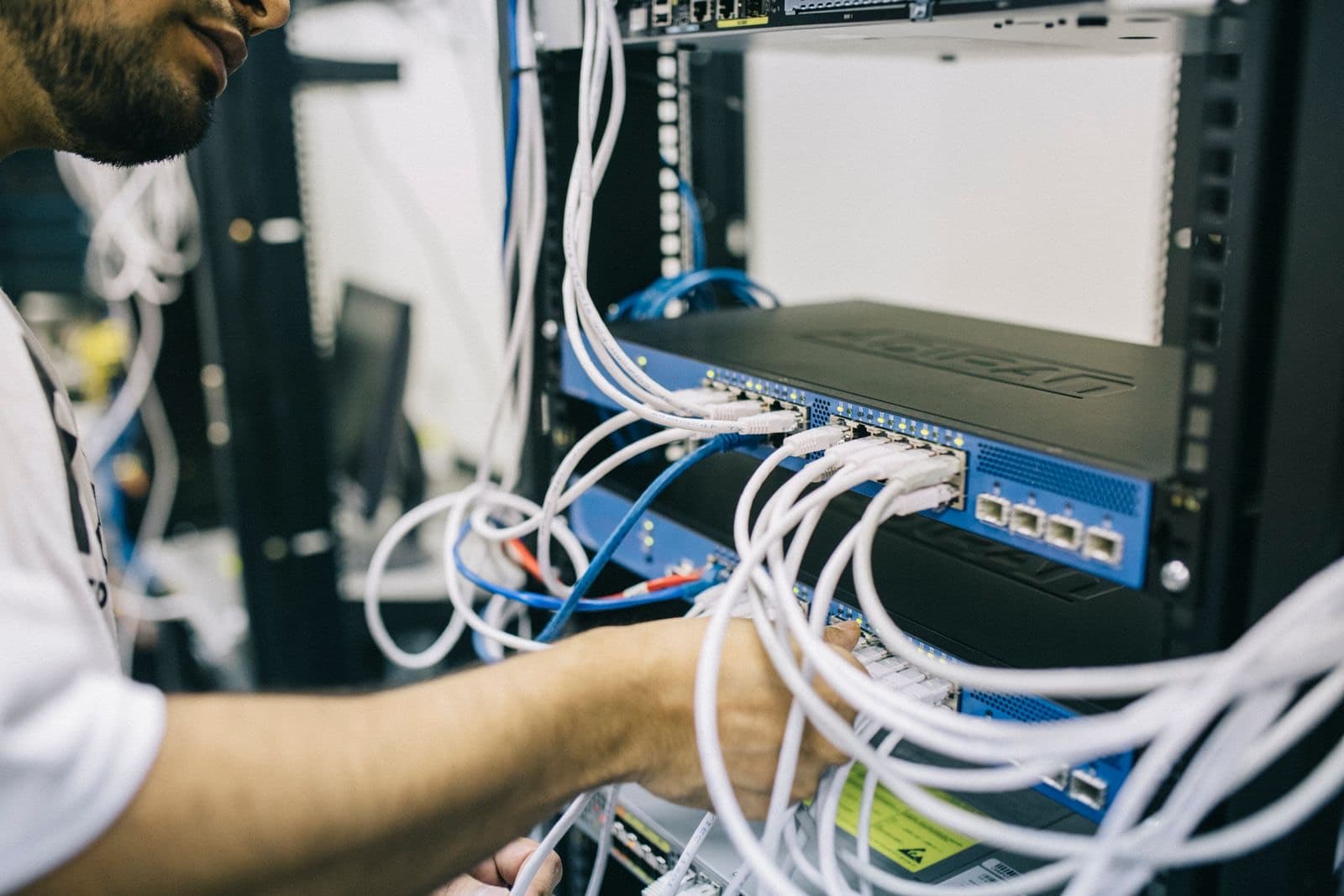 Técnico conectando cableado de red en un rack de comunicaciones